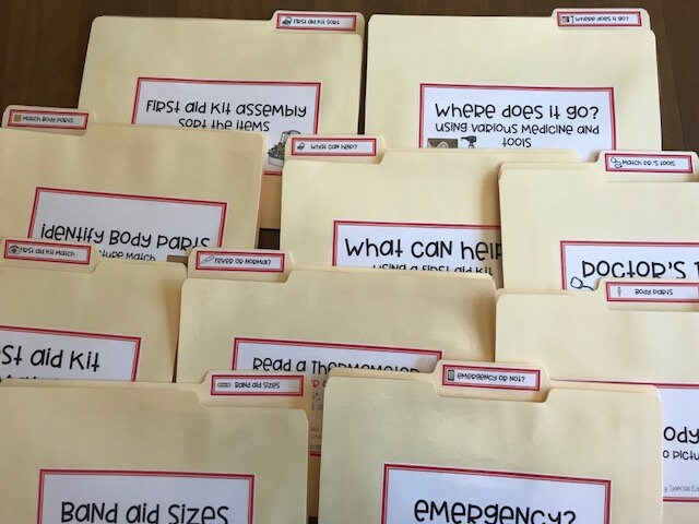 Laminated file folders with various labels attached with Velcro dots, designed for speical education purposes related to first aid and health skills.
