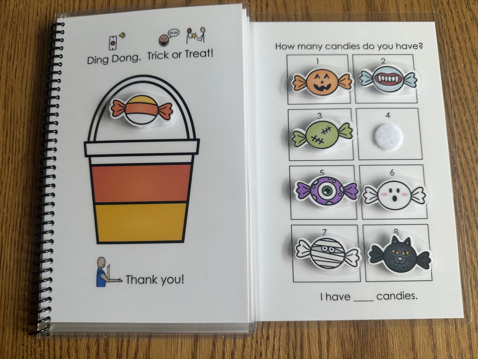 Special Education adapted book with Halloween-themed pages, moveable pieces and symbol supported text on a wooden surface