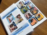 Open book titled 'Community Helpers' with interactive cards on a wooden surface