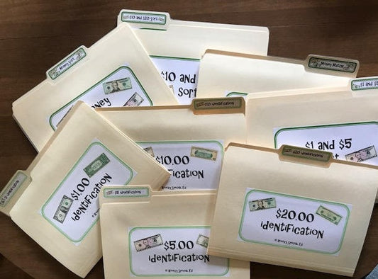 A collection of life skill laminated file folders with Velcro dots, labeled with different money identification and sorting activities, for special education